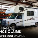 An RV Camper parked at a Workshop for Roof Damage Jobs