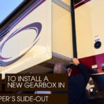 Two Men Inspecting the Slide-Out Gearbox of a Camper