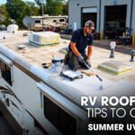 A Male Technician Doing Roof Coating of a Class A Motorhome Parked Outside of a Workshop