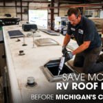 A Male Technician Repairing an RV's Roof Inside a Workshop