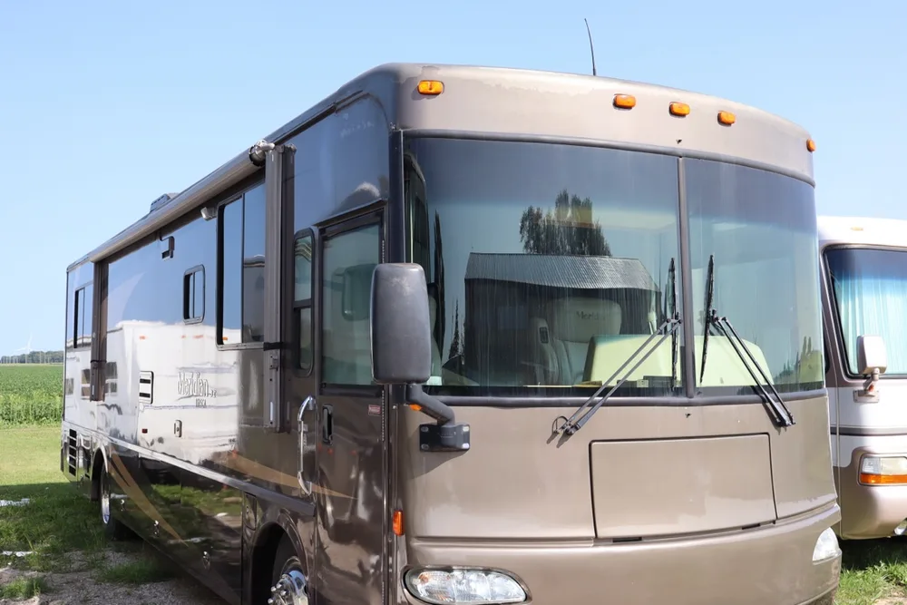 Brown and taupe Itasca Meridian Class A motorhome, front three-quarter view, glossy in the yard at Nagel Trailer Repair